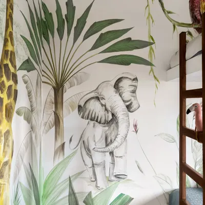 A close-up of the hand-painted jungle mural, a centerpiece of this child's room. We collaborated with a local artist to bring the safari to life, turning the walls into a canvas for adventure.