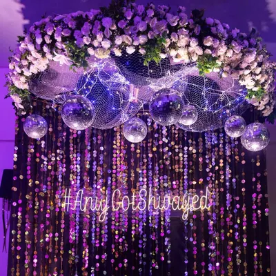 A custom neon sign with the couple's hashtag, '#AnujGotShwayed', served as a cool, modern photo backdrop against a wall of shimmering sequins and disco balls.