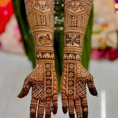 This is a classic full-coverage bridal design featuring traditional Indian motifs like elephants and temple domes (gumbad), with detailed checkerboard patterns on the fingers.