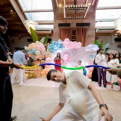 It's not a baby shower without some fun and games! Here, guests are having a great time playing limbo, bringing a ton of laughter and energy to the party.
