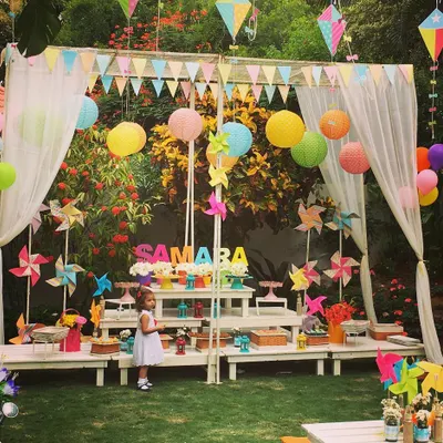 A delightful summer picnic party for a 2nd birthday. The setup featured a dessert canopy decorated with colorful lanterns, pinwheels, and kites for a fun, breezy feel.