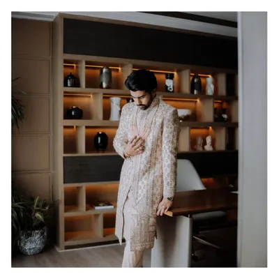 A portrait of the groom, looking sharp and sophisticated in his sherwani, captured in a moment of quiet reflection before the ceremony begins.