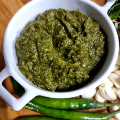 This is my special 'dardari' or coarse green chutney. I make it by blending fresh coriander, mint, green garlic, green onions, and tomatoes with a mix of spices for a zesty kick.