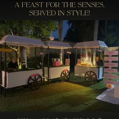 My live cooking stations are a feast for the senses. These elegant white food carts, including a popcorn machine, are perfect for outdoor events, allowing my chefs to craft sizzling delights fresh for your guests.