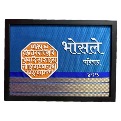 A clear, straight-on shot of the 'Bhosle Parivar' nameplate. This custom piece features 3D lettering and the iconic Shivmudra against a textured blue background with a Paithani saree border.