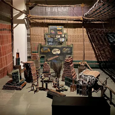 The central installation of Archana Hande's 'WEAVING LIGHT'. This piece, resembling a loom, was created with stacks of textile punch cards and became the centerpiece of a dark, immersive environment filled with light and shadow.