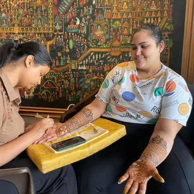 A happy client is the best reward. Here I am applying a bridal design, and her smile shows she is more than satisfied with the service.