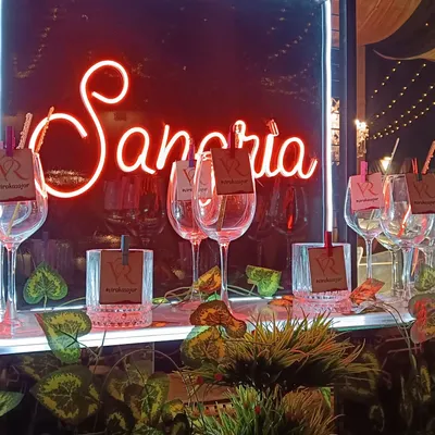 A close-up of our popular Sangria station, complete with a neon sign and personalized glass tags featuring the couple's initials. It's a stylish and interactive way for guests to enjoy a refreshing drink.