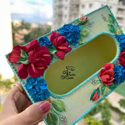A bright and cheerful tissue box featuring vibrant red roses and blue hydrangeas on a subtle yellow-green base. The textured turquoise border adds a lovely finishing touch.