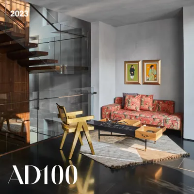 A lounge area from our AD100 award-winning Baid Residence. This space features a custom sofa, a brass chair by Mahendra Doshi, and a coffee table from Mogg Design, all set against sleek black granite flooring.