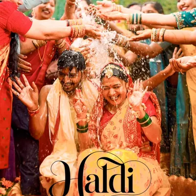 A quintessential Haldi shot, capturing the couple being showered with water and blessings by their loved ones. This image is all about pure, unadulterated joy.