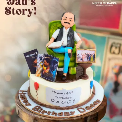 A slice of Dad's story! This cake for a 60th birthday captures his favorite things: relaxing in his chair, watching movies, and treasured family photos.