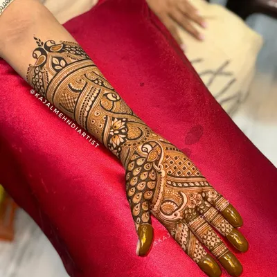 A full-arm bridal henna design that is all about detail. This piece combines classic Indian paisley, peacock feathers, and floral patterns for a rich and traditional look that extends up the forearm.
