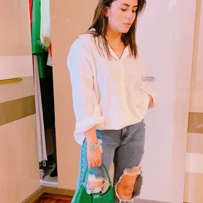 The classic white shirt and ripped jeans combination is a timeless look. I elevated it here with a pop of color from a structured green handbag, showing how accessories can refresh a wardrobe staple.