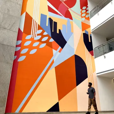 This 100-foot tall mural for the Embassy Group is a story of harmony between nature and urban development. The abstract design uses bold colors and shapes to create a landmark piece in their corporate lobby.