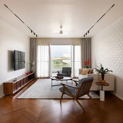 The living room of the 'House of Skye' combines a simple, sophisticated material palette: a whitewashed brick wall, warm herringbone wood floors, and comfortable, modern furniture.