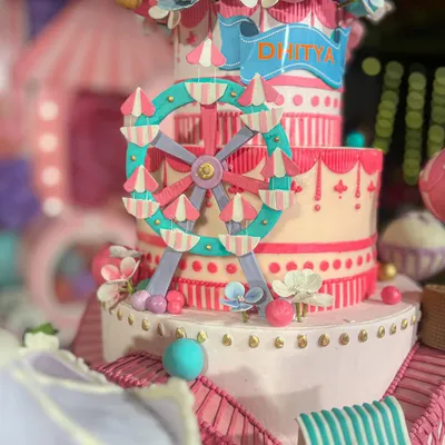 A close-up of the carnival cake's centerpiece, a hand-painted, edible ferris wheel. My background in architecture means I get obsessed with creating these structural, detailed elements that make a cake truly special.