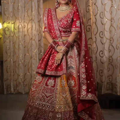 This multi-panelled bridal lehenga combines traditional red with shades of yellow and intricate silver embroidery. It's a perfect choice for the bride who wants a unique, vibrant, and classic look all in one.