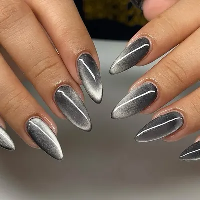 Sleek, sharp, and impossibly cool. This set of stiletto nails features a silver cat eye effect, creating a striking metallic line that shifts and glows against the dark, moody base.