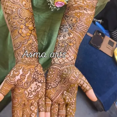 A full-coverage bridal design showcasing intricate floral and paisley patterns that extend from the wrist to the elbow for a classic, elegant look.