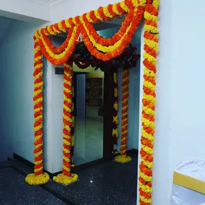 This is a classic decoration for a housewarming or puja. I wrapped the entire door frame with twisted garlands of orange and yellow marigolds, creating a full and traditional festive look.