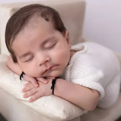 A close-up of pure serenity. I focus on capturing the peaceful expressions of a sleeping newborn, highlighting the delicate features that you'll want to remember forever. This is a classic pose from my newborn portrait sessions.