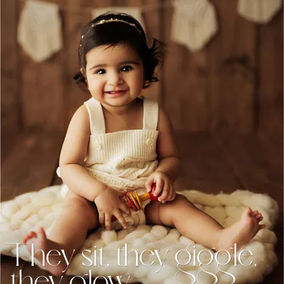 They sit, they giggle, they glow. This is the heart of a sitter session, capturing that perfect smile on a simple, rustic setup with a cozy wool blanket.
