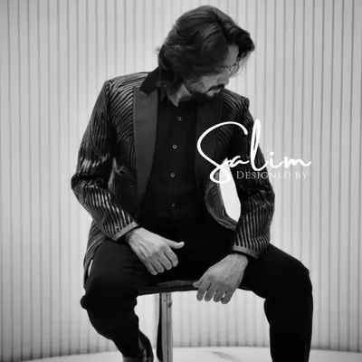 A black and white shot of a client in a striped blazer. This photo highlights the texture of the fabric and the sharp cut of the jacket.