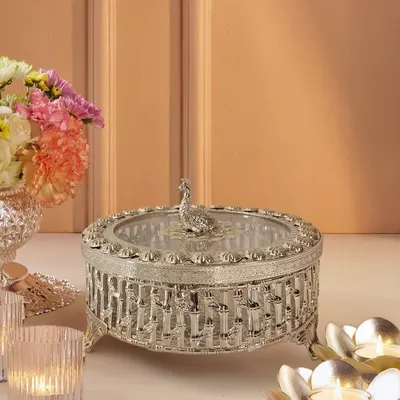 This silver-plated dry fruit box is a masterpiece of intricacy. I designed it with a lattice-work body and a regal peacock knob, making it as much a decorative treasure as a functional serving piece.