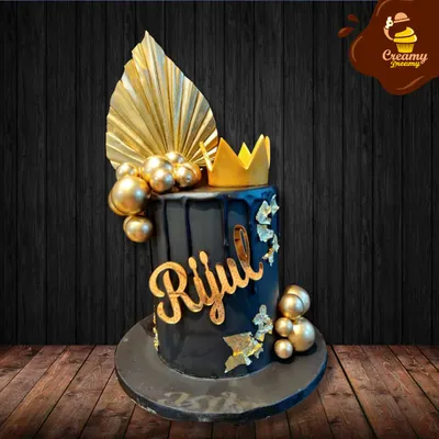 This black and gold cake is pure elegance. The dark, glossy finish is contrasted with a gold drip, a personalized name, and topped with a crown, making it fit for royalty.