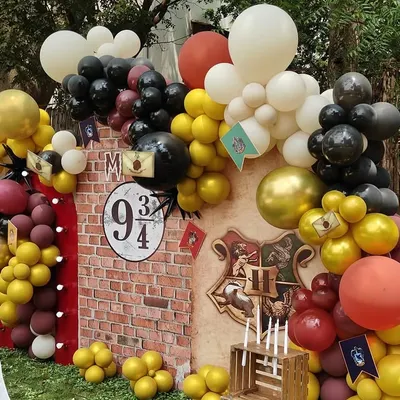 A detailed look at the Harry Potter backdrop, featuring the iconic Platform 9 3/4 sign and Hogwarts house flags.