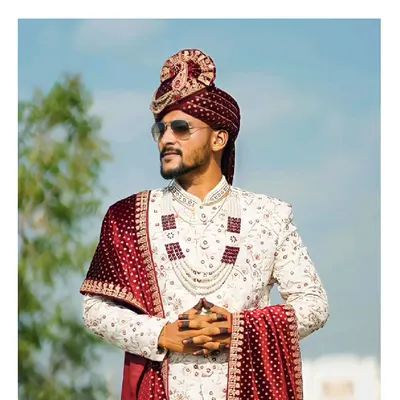 Be the groom that looks his regal best. Our client looks stunning in this classic ivory sherwani with maroon accessories, a perfect royal look for the D-day.
