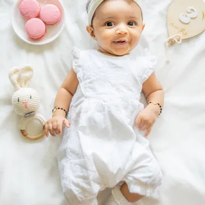 This three-month milestone portrait is a perfect example of my style. I use soft, natural light and a neutral palette to create a classic image. The focus is on your baby's adorable features and happy expressions, with just a few simple props to mark the occasion.
