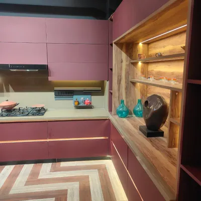 A closer look at the details of our modern magenta kitchen. The handle-less cabinets create a seamless look, while the open wooden shelving unit with integrated lighting provides a warm contrast and a beautiful display area.