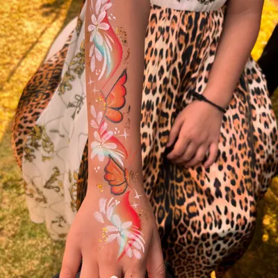 A beautiful cascade of butterflies and flowers painted on the arm. This is a stunning piece of wearable art for any occasion.