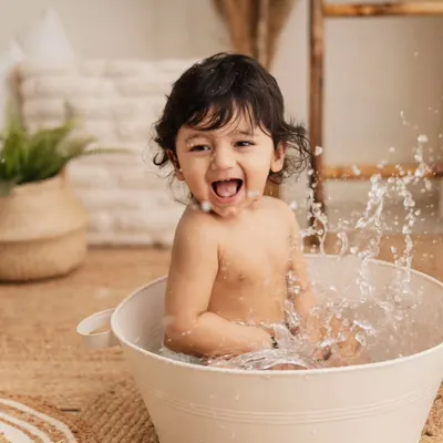 The best part of a birthday shoot? A fun splash in the tub afterwards! This little guy is having the time of his life, and his joyful expression is priceless.