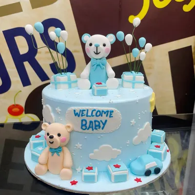 A sweet 2kg "Welcome Baby" cake in blue, adorned with cute fondant teddy bears, presents, and balloons.