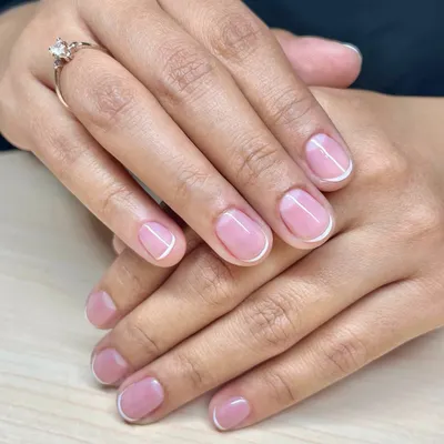 A classic and clean look. This is a simple French manicure on short, natural nails, finished with a glossy gel polish for a healthy shine.