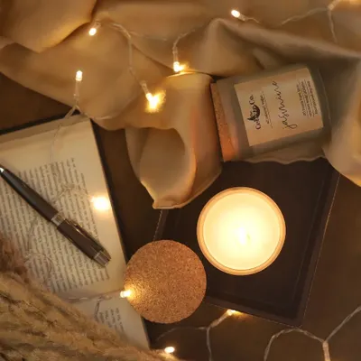 This overhead shot creates a cozy, relaxing mood for a scented candle. I styled it with an open book, a pen, and warm fairy lights on a soft fabric to evoke a perfect evening of reading and unwinding.