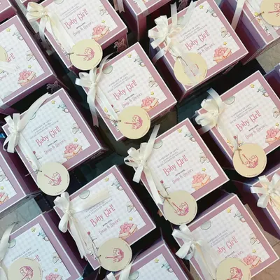 The sweetest way to share the sweetest news. These custom baby announcement favours feature adorable "Baby Girl" themed cards and tags, tied with white ribbons to our classic pink boxes.