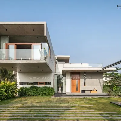 The Quarry House, defined by its bold 18-foot cantilevered concrete volume. The design creates a powerful architectural statement while maintaining a harmonious relationship with the surrounding lawn and linear stone pathways.