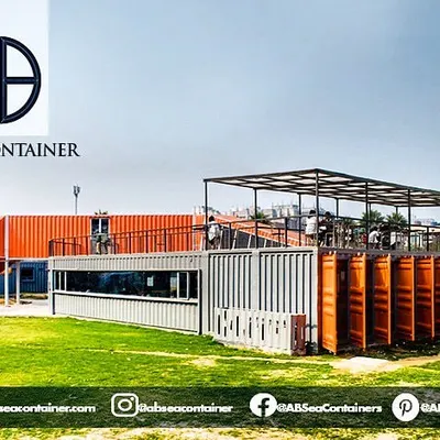 The 'Cafe Infinity' project, shown here in its urban setting, transforms industrial containers into a vibrant public space. The structure combines open-air terraces with enclosed dining areas.