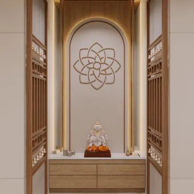 A beautiful custom pooja unit designed as a serene sanctuary within the home. It features an arched niche with soft backlighting, a geometric mandala, and elegant latticework doors for a modern yet reverent feel.