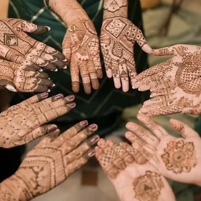 A beautiful moment captured with the bride and her bridesmaids, all showing off their unique mehndi designs. We love creating a festive atmosphere for the entire bridal party.