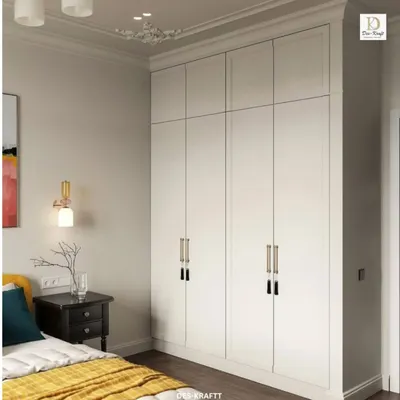 A detail of the custom white wardrobe with elegant, modern handles, providing a clean and neutral balance to the room's more colorful elements.