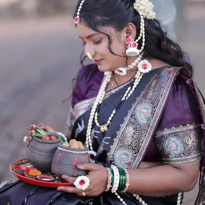 The complete Makar Sankranti look, featuring a black saree with a peacock border, a purple blouse, and the special halwyache dagine.