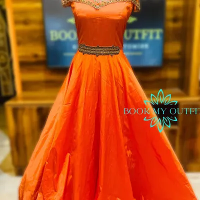 Make a bold statement in this vibrant orange ball gown. The intricate, high-neck beadwork and belted waist create a regal silhouette, making it an ideal rental for sangeets, weddings, or formal gatherings.