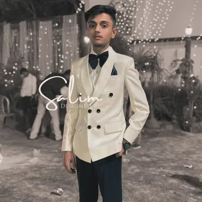 A young client in a custom white double-breasted tuxedo. This miniature version of a classic style is perfect for weddings and family celebrations.