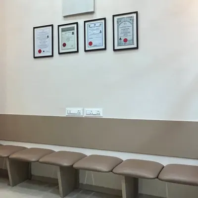 The patient waiting area provides a comfortable and private space for you before your appointment. You can see my qualifications and certifications displayed, reflecting my commitment to expert care.