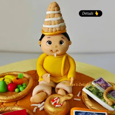 A close-up of the fondant baby topper from the Annaprashan cake. I took great care in sculpting the traditional Bengali topor (headwear) and the tiny details like the bowl of kheer.
